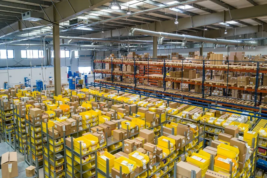 A worker scanning inventory in a warehouse aisle